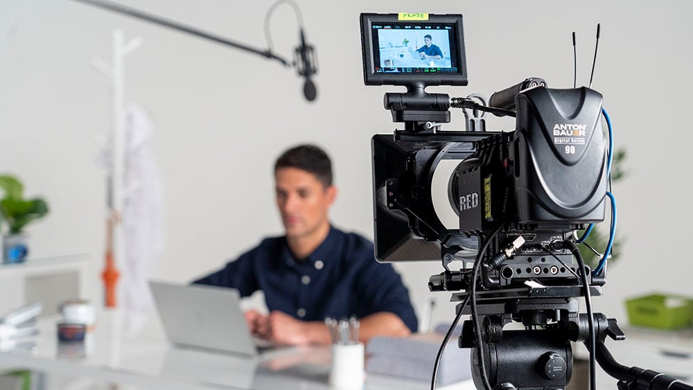 Male actor sitting on video production set in an office environment